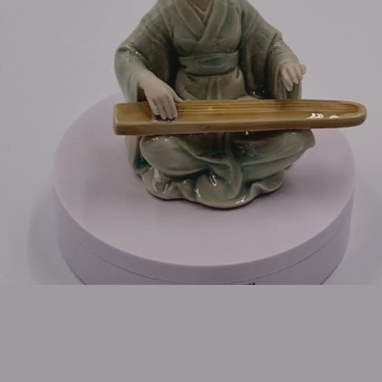 Chinese figure playing the guqin seated