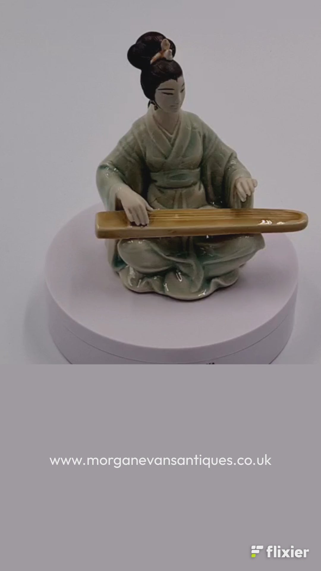 Chinese figure playing the guqin seated